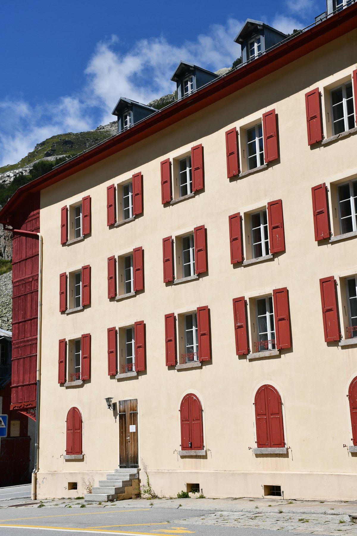 Façade d'un immeuble locatif suisse aux volets rouges