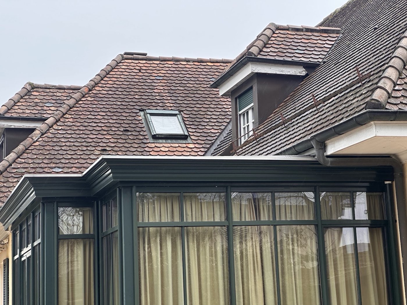 Véranda et toiture de la villa à Anières, vues depuis le jardin